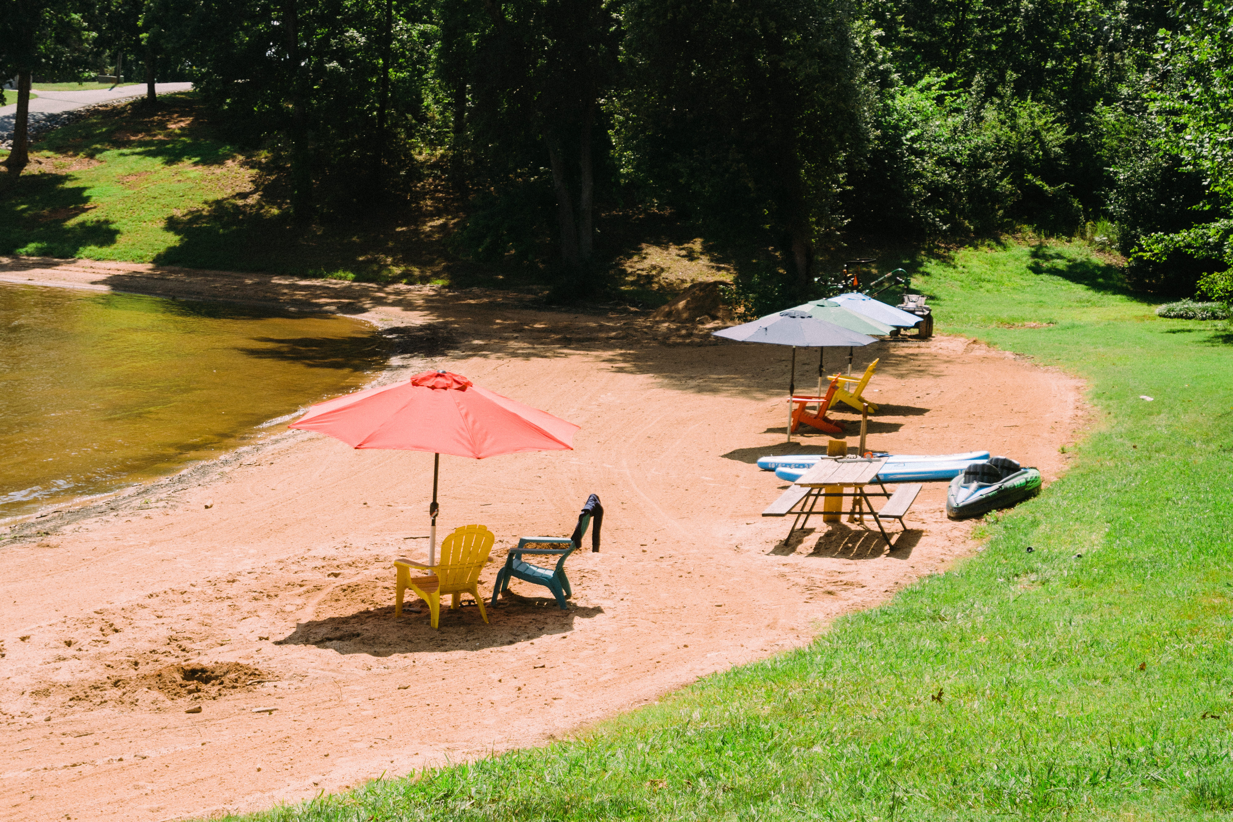 Private sand beach on Lake Hickory with kayaks, paddleboards, and umbrellas